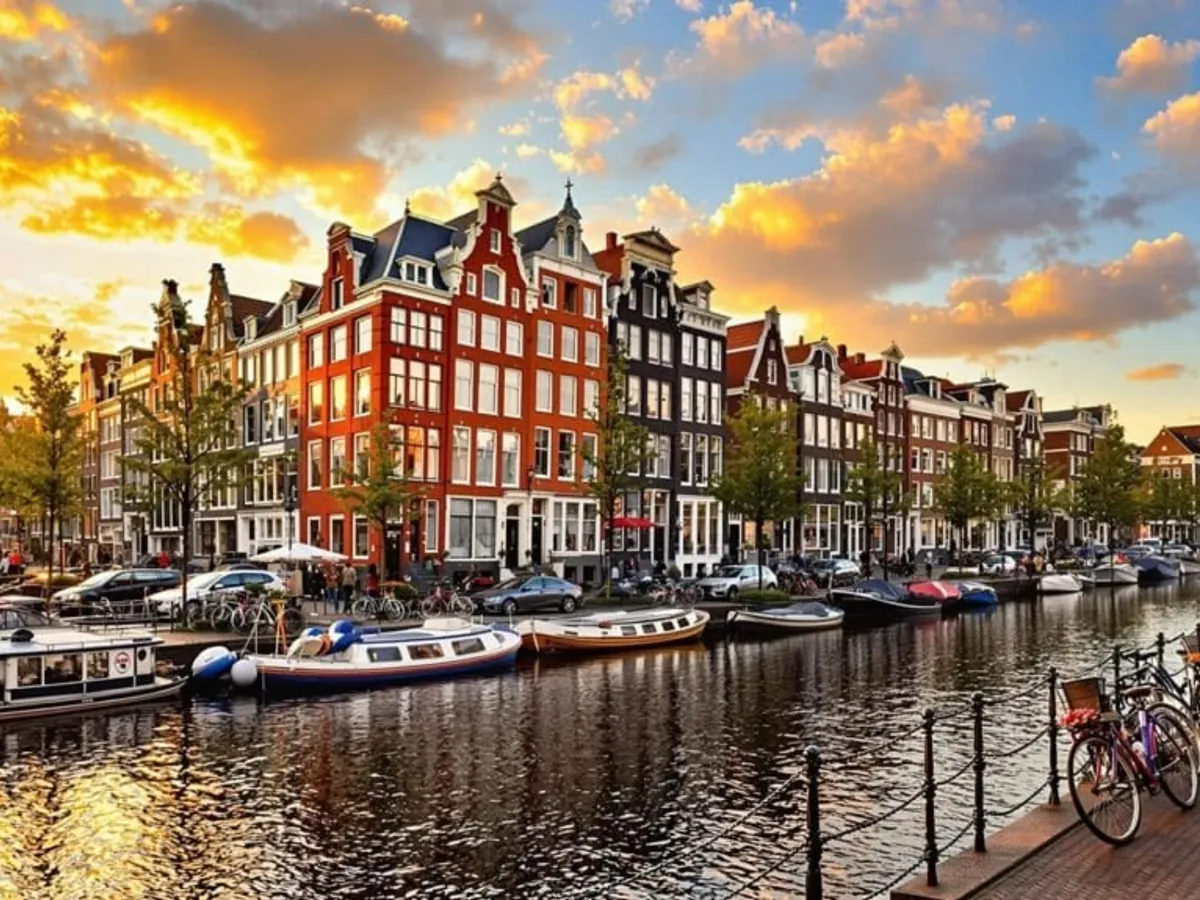 Casas e canal de Amsterdam ao pôr do sol